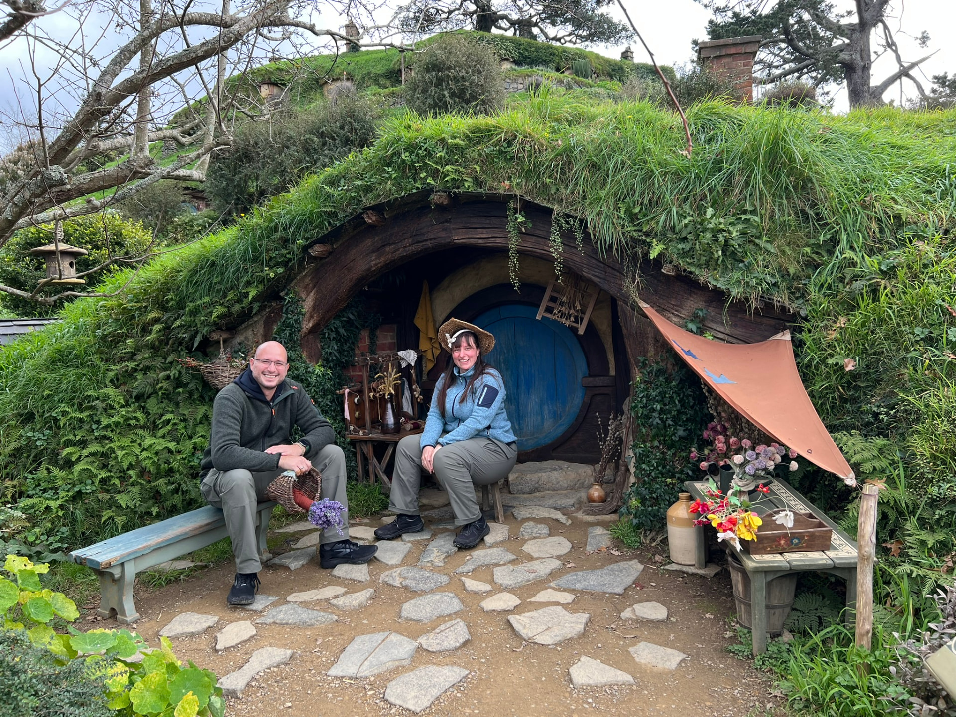 Nadja und Partner vor einem Hobbit-Haus in Hobbiton