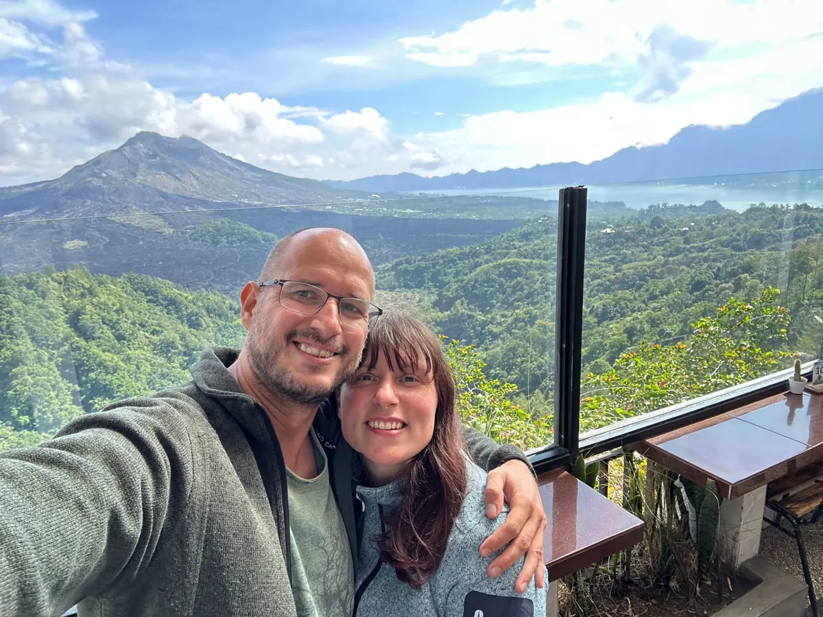 Jan und Nadja lächelnd vor dem Vulkan Batur auf Bali